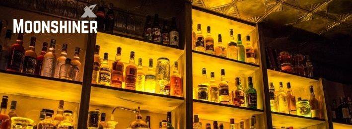 étagère remplie d'alcool derrière un bar